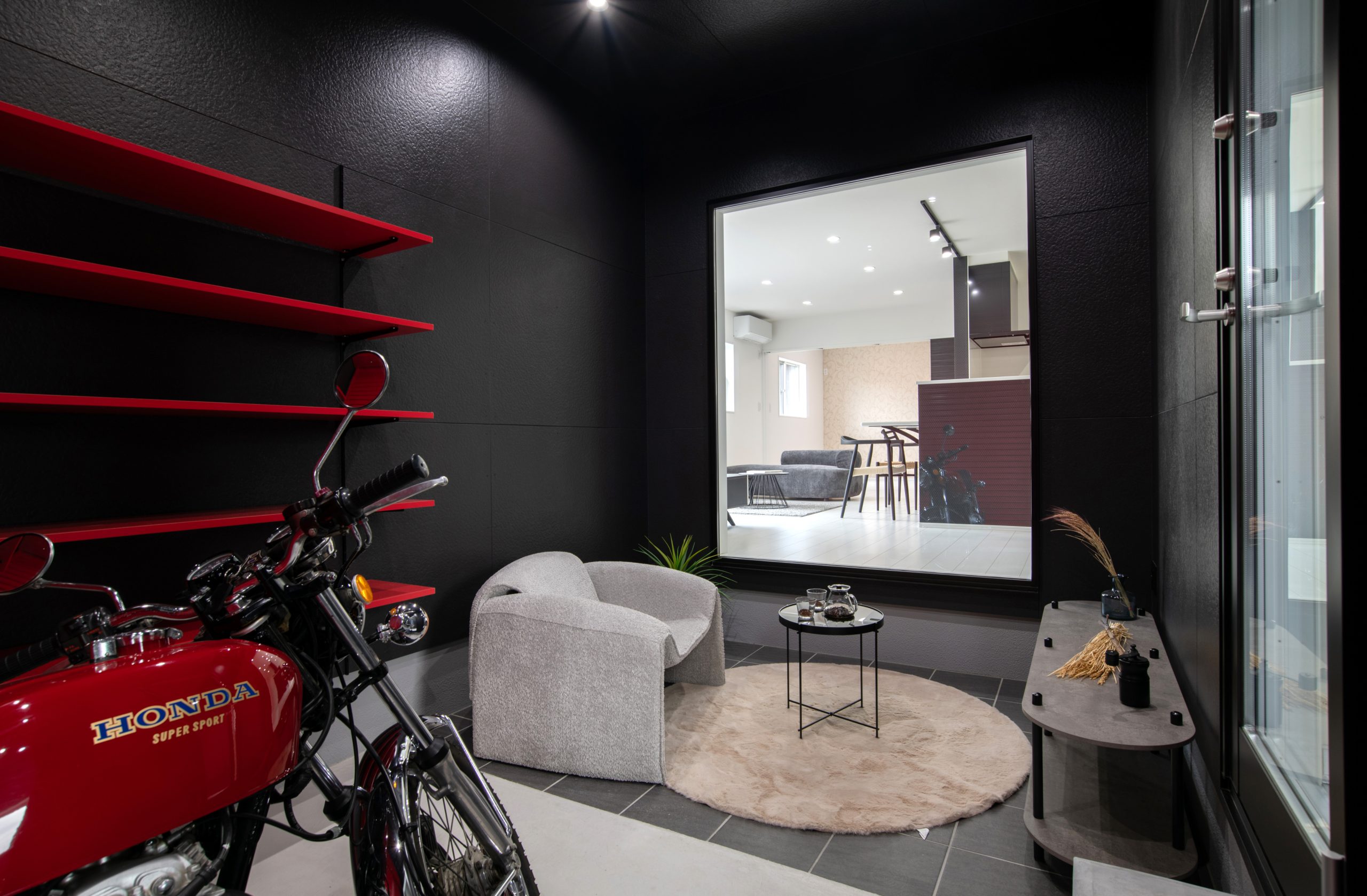 バイクガレージの中にくつろぎスペースのある趣味を詰め込んだ平屋